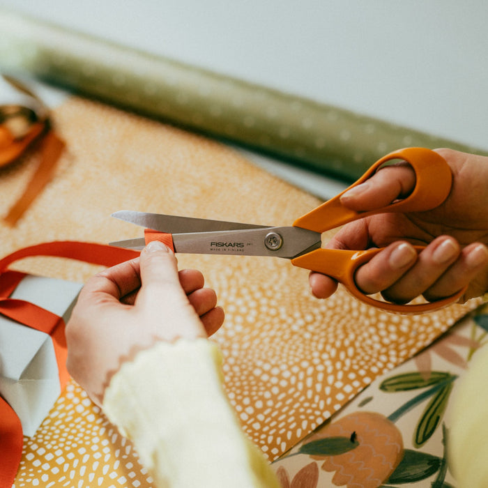 Cutting with Fiskars orange-handled Universal scissors 